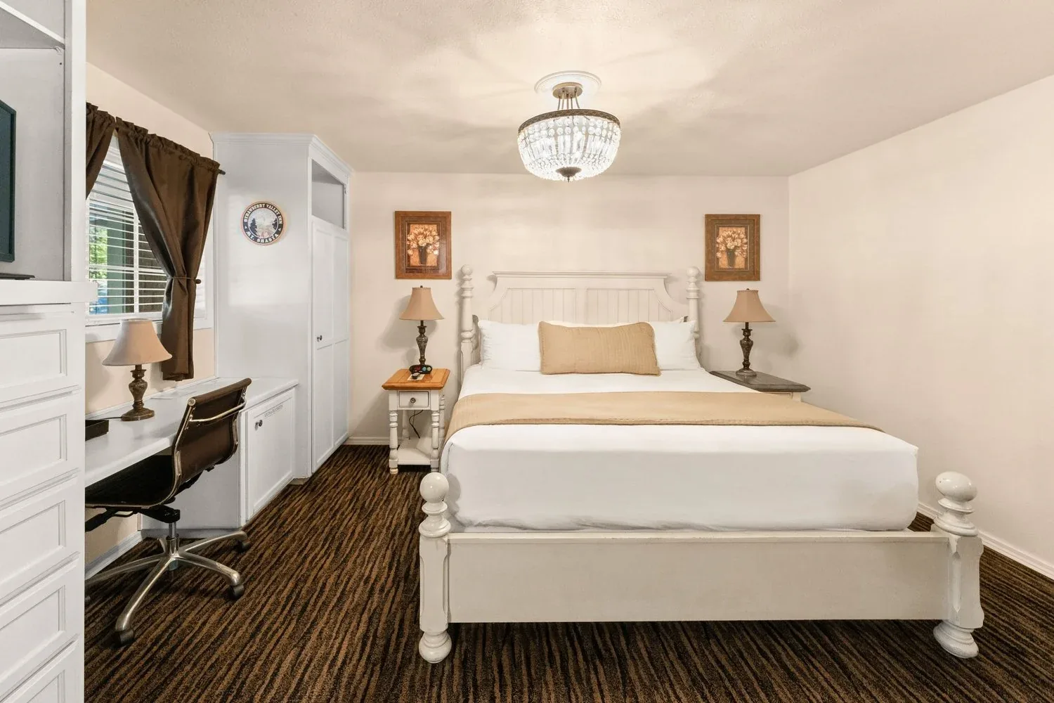 King Suite with a white bed and chandelier