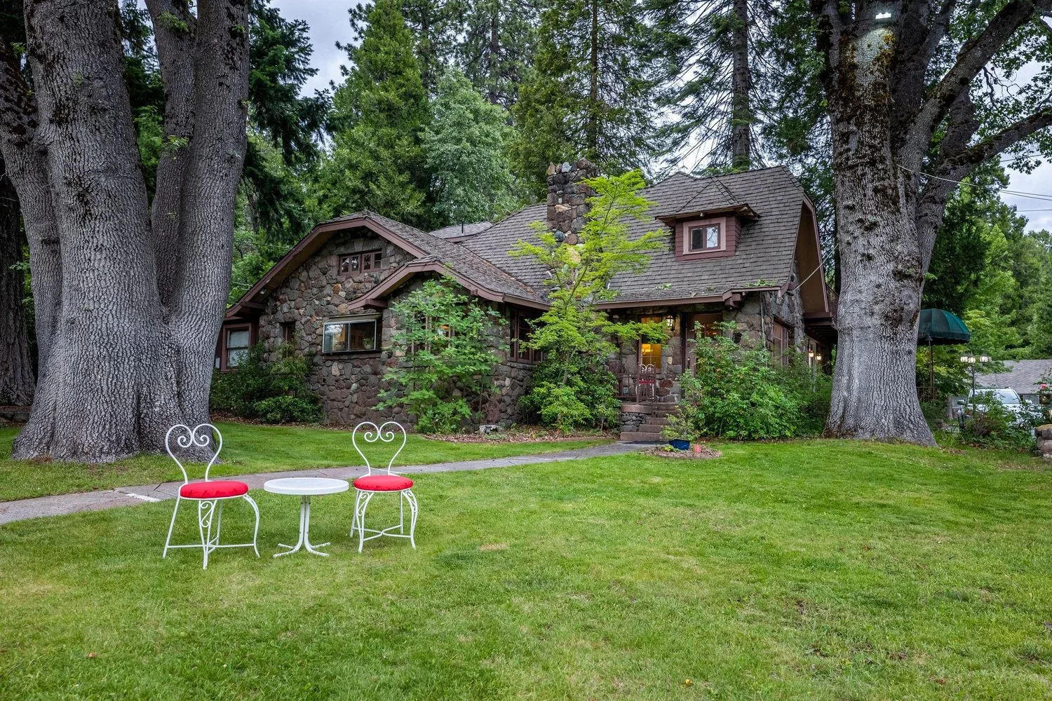 The stone lodge with a table and chairs on the garden lawn